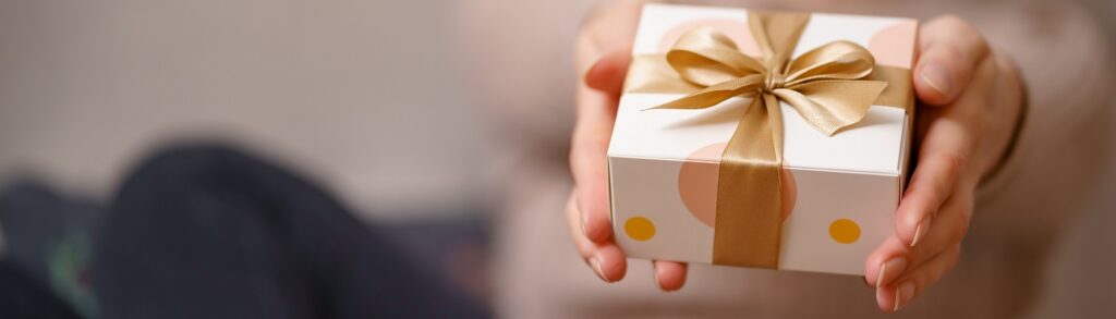 Gifts category background image with a woman holding a wrapped gift.
